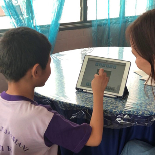 Student with teacher on an aac device