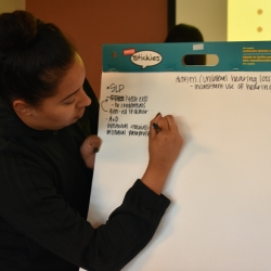 Student writing on whiteboard during discussion